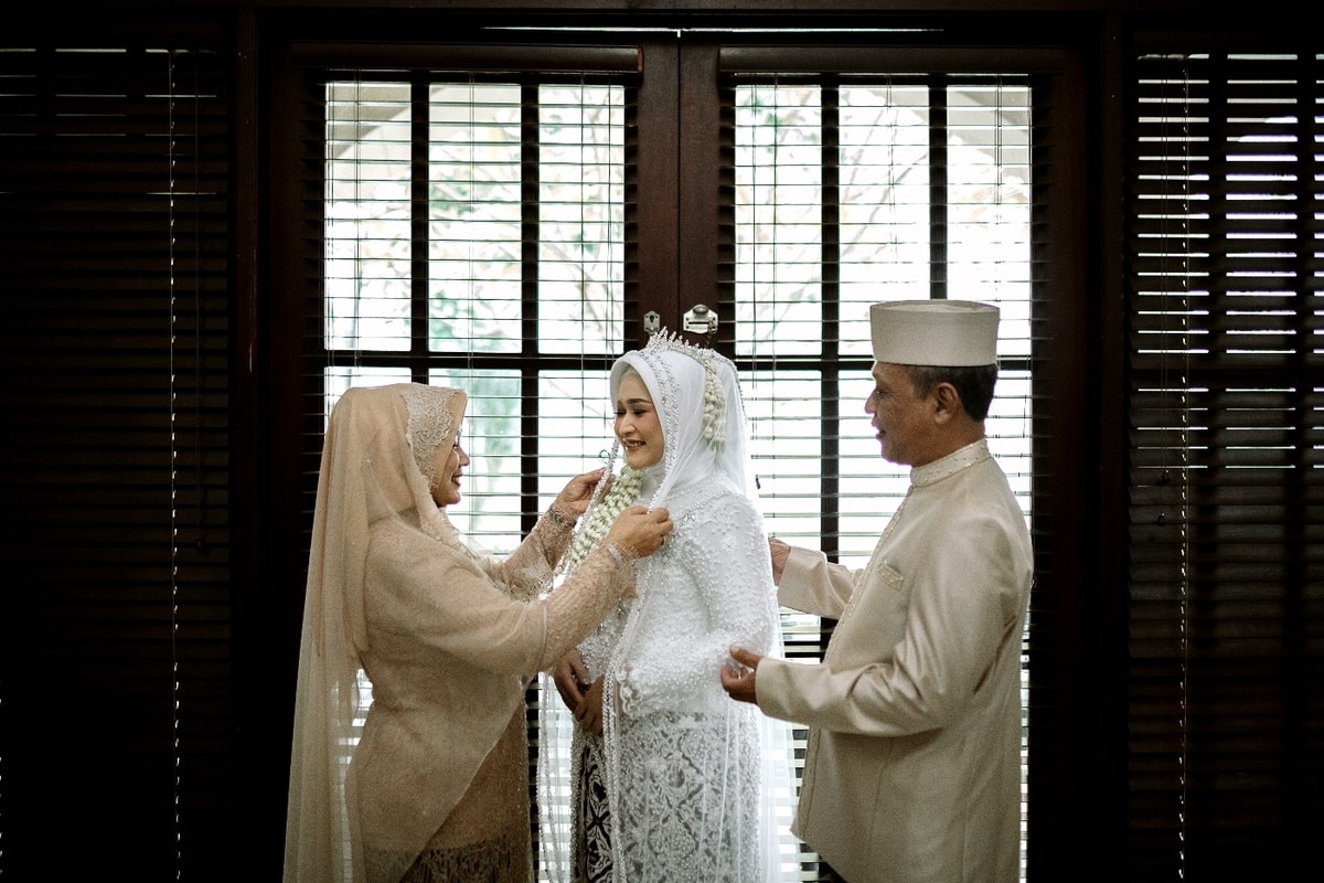 Tampak pengantin wanita sambil berbincang dengan orang tuanya, momen hangat dan sentimental yang diabadikan oleh team Besokpagi.